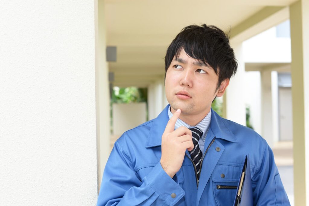 考える作業着の男性